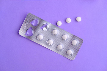 top view of white pills on color background. 