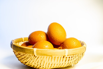 Fresh eggs with water condensation in a rattan basket. Isolated on white. Shallow depth of field.