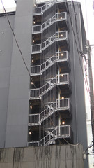 Naklejka premium Fire escape stairs on black painted residential tall building