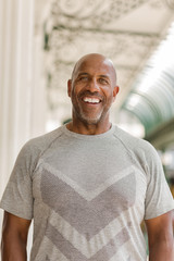 Happy mature African American man smiling outside.