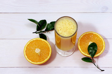 A glass of fresh orange juice and orange fruits on a wooden table. Healthy food.  