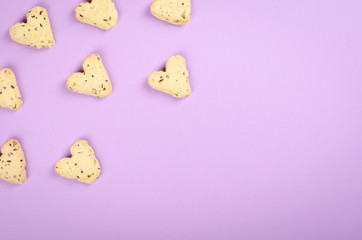 Flax seed cookies on purple background composition, heart shape.