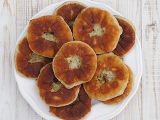 Belyasha homemade baking with meat on a white rustic wooden table.