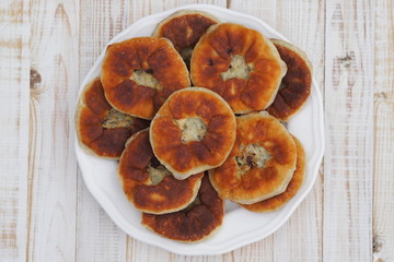Belyasha homemade baking with meat on a white rustic wooden table.