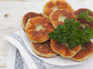 Belyasha homemade baking with meat on a white rustic wooden table.