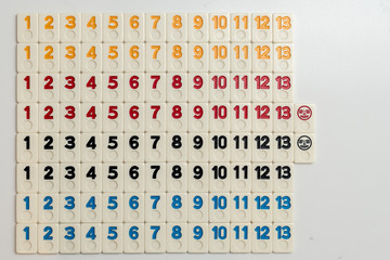 Grid of numbers in colors from 1 to 13 made out of rummy pieces