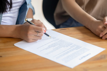 Close up female client signing business contract, making legal deal
