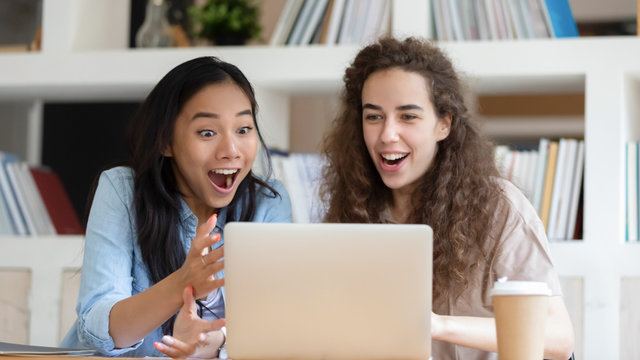 Horizontal photo excited surprised diverse girls looking at laptop screen