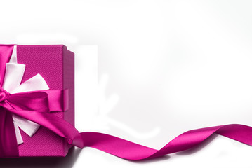 Pink gift box with bow and ribbon on a white background, isolated image