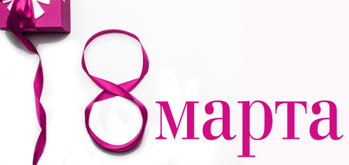 8 March. Decorative pink bow with gift box isolated on white background.Inscription in russian 8 March