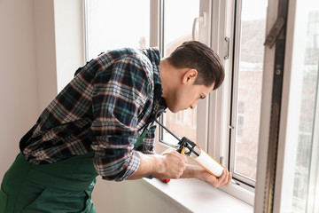 Fototapeta na wymiar Male worker installing window in flat