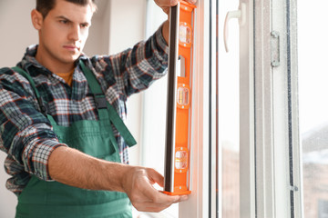 Fototapeta na wymiar Male worker installing window in flat