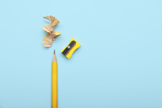 Ordinary pencil and sharpener on color background