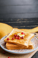 Tasty toasted bread with honey, butter and berries on plate