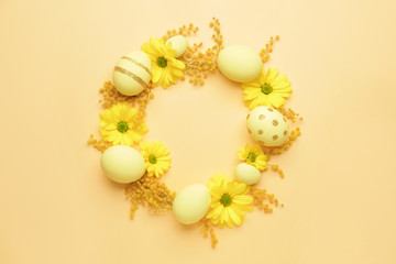 Beautiful Easter eggs and flowers on color background