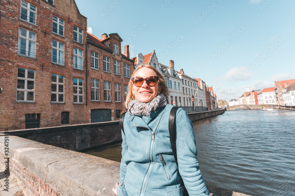 Wall mural woman tourist sitting and enjoying a center of bruges, belgium