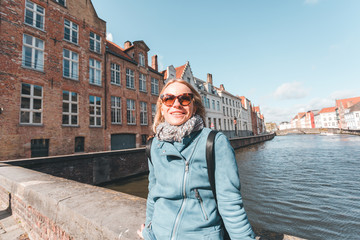 Fototapeta na wymiar Woman tourist sitting and enjoying a center of Bruges, Belgium