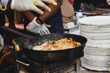 Cooking omelette on frying pan at market stall