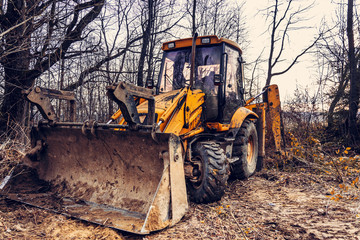 The excavator works in the forest in clearing the forest.