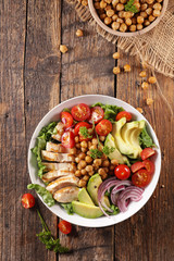 mixed vegetable salad with avocado, chicken, chickpea, onion and tomato