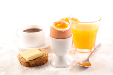 boiled egg, toast with butter, coffee cup and orange juice