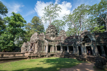 The scenery of an ancient stone door with clear blue sky, Ta Prohm temple ruins, Angkor, Cambodia.