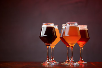 Three glasses with different beer on wooden table in a bar. Food photography concept, with copy space