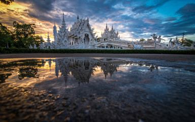 Naklejka premium The scenery of reflection of Wat Rong Khun or White temple on sunset time in Chiang Rai, Thailand.