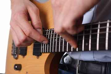 Male arms holding and playing classic shape wooden electric guitar closeup. Six stringed learning...
