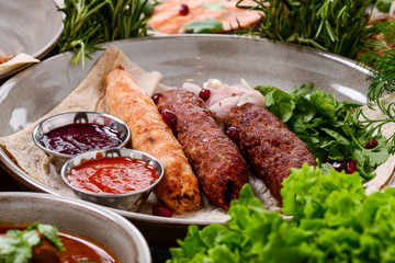 Traditional georgian cuisine. Kupati chashululi chkmeruli roasted sausages. Georgian sausage made from lamb in ketsi pot