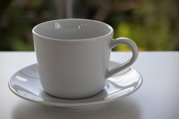 Close up A white coffee cup placed by the window