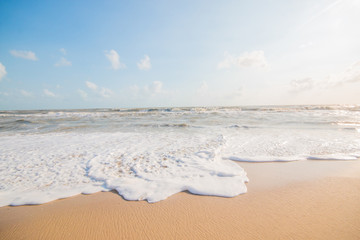 Sea water bubble at the beach and beautiful wave in background.