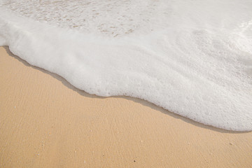 Sea water bubble at the beach and beautiful wave in background.