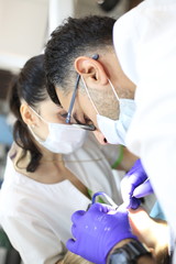 dentist is diagnosing the child while assistant  in dental clinic.