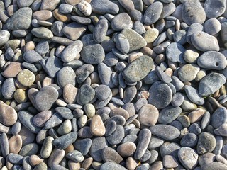 Pebbles on the beach. Abstract background with round pebbles stones
