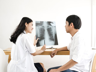 Obraz premium Asian doctor showing x-ray results to her patient.