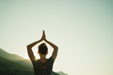 Young woman doing yoga workout at sunrise