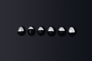 Six black and silver Easter eggs on a black background. Flat lay, top view, copy space.