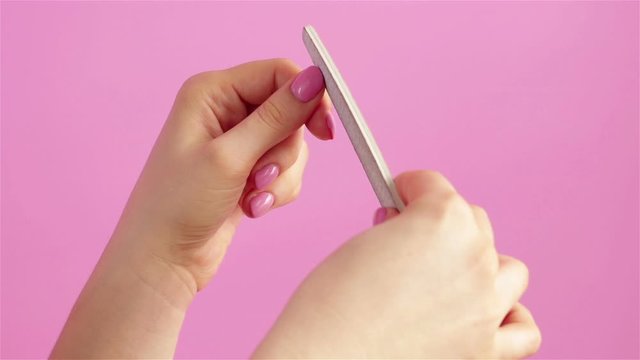 woman hands doing manicure with nail file close up