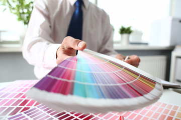 Employee refueling cartridge service holds magnifying glass in hand. Color print of pantone...