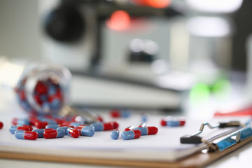 Tablets scattered blue and red color on the table of pharmaceutical laboratory pill for the prescription and treatment various diseases chemistry