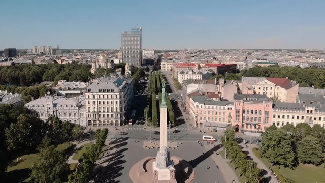Beautiful aerial drone shot in City center of Latvia's capital Riga from Sunny summer day with and statue of freedom - Milda. People and cars passing by