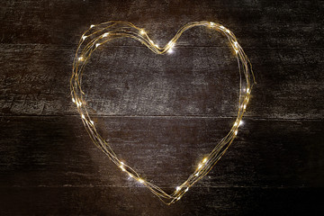 A heart-shaped led frame is placed on a wooden background. space for text. blank for a postcard