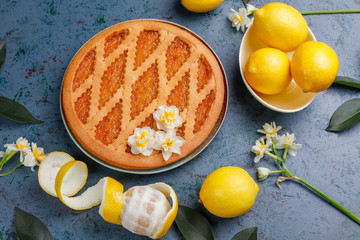 Delicious lemon pie with fresh lemons on dark background,top view