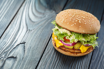 Delicious burger on wooden background with copy space