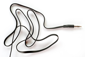 3.5 mm plug with a black wire, shot large on a white background. Background for music and computer equipment
