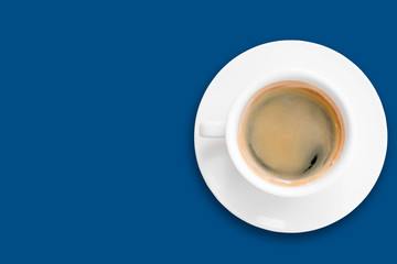 black coffee in a ceramic coffee cup above saucer in white color isolated on classic blue background