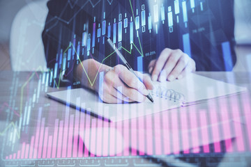 Forex graph on hand taking notes background. Concept of research. Multi exposure