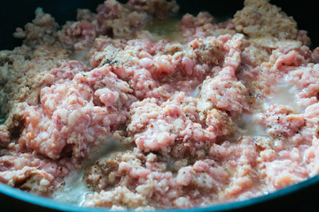 Raw minced meat in a frying pan.  Cooking minced meat  on frying pan.
