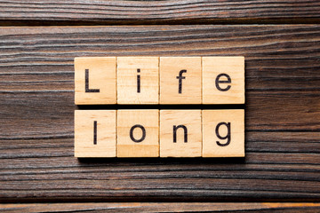 life long word written on wood block. life long text on table, concept